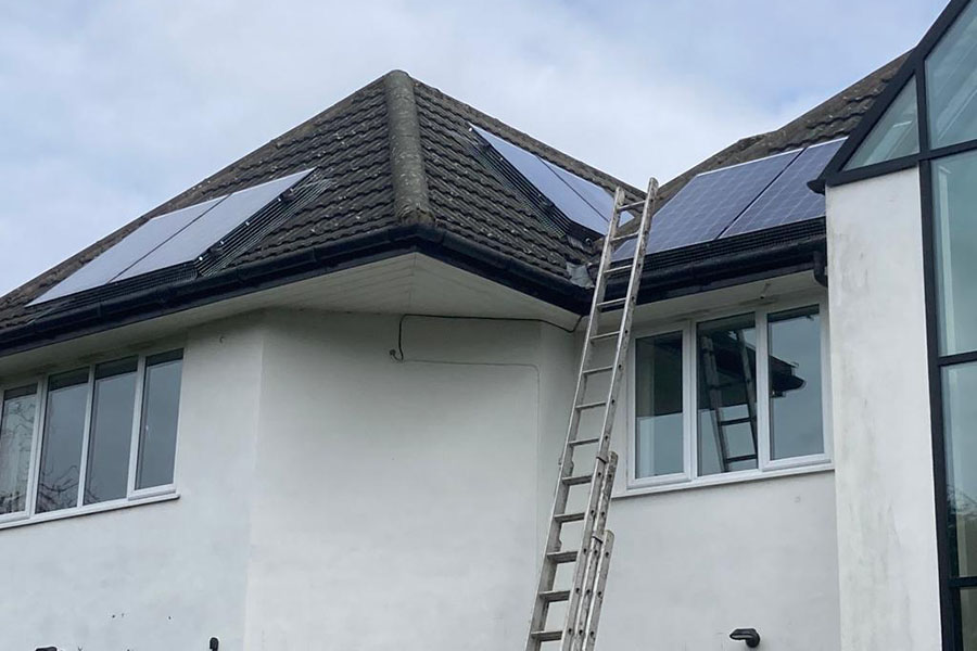 A bird proofing installation being carried out to solar panels on a residential building.