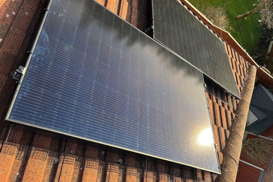 Two solar panels with bird proofing mesh methods on a residential property.